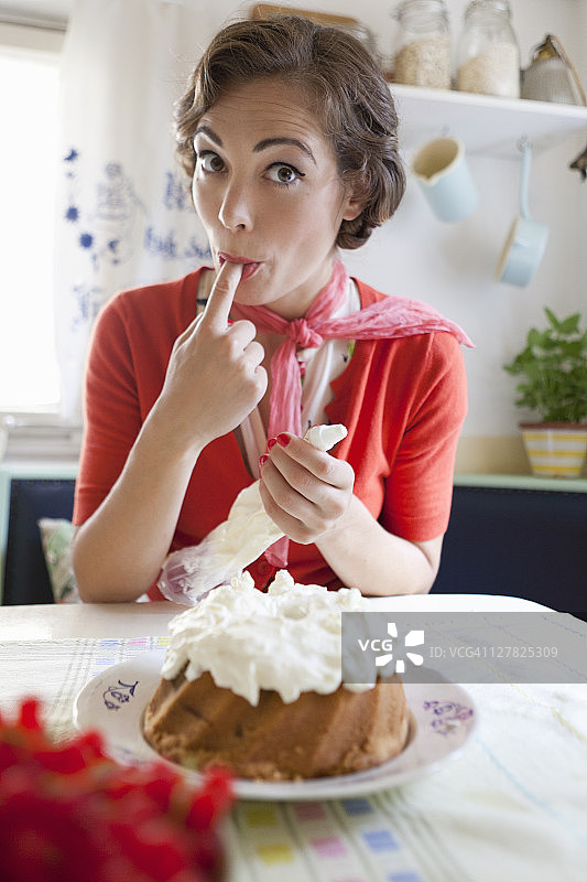 女人在厨房给蛋糕抹糖霜图片素材