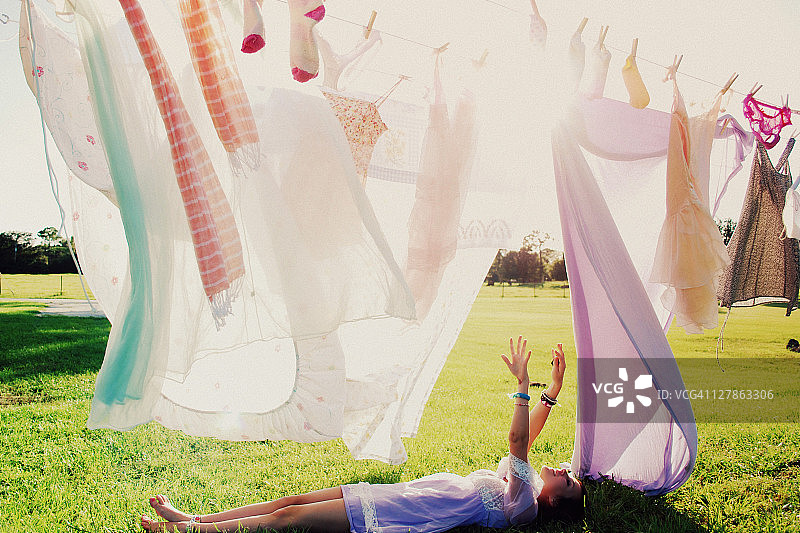 躺在草地上、晾衣绳边的女孩图片素材