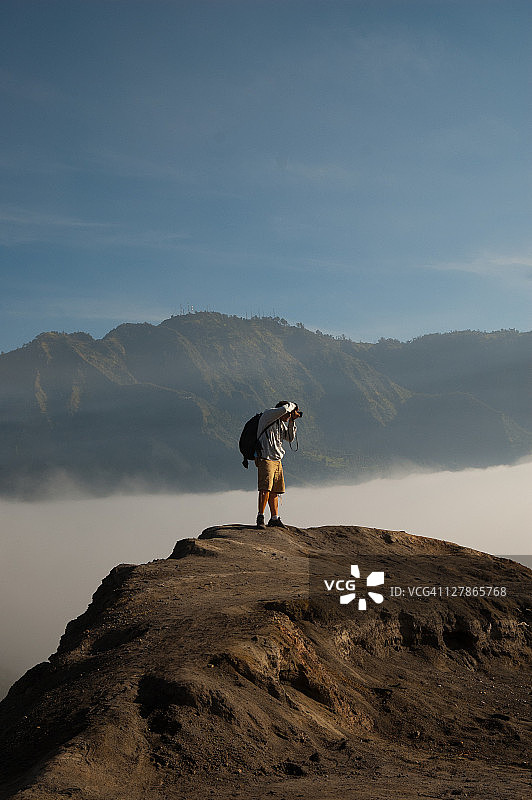 在雾蒙蒙的山顶上的摄影师图片素材