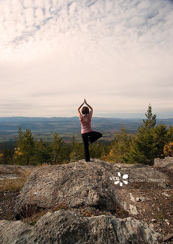 在山顶上做瑜伽的女孩图片素材