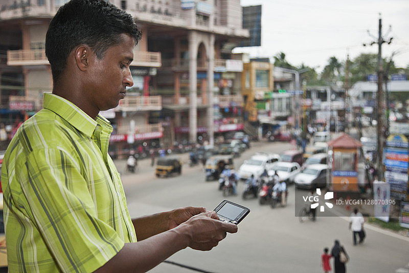 34岁男子在印度喀拉拉邦科钦市街角用手机与朋友交流图片素材