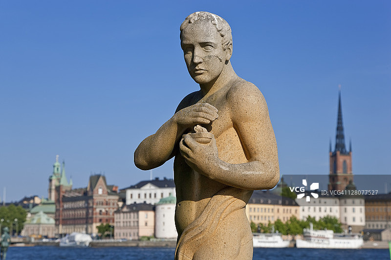 斯德哥尔摩市政厅外的卡尔·埃尔德的诗人雕像，背景是骑士岛，瑞典图片素材