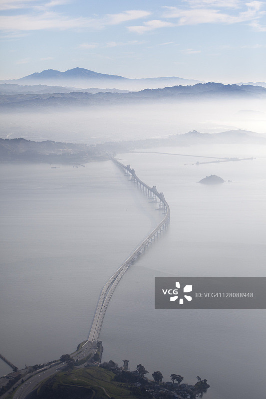 美国加利福尼亚州旧金山湾，里士满-圣拉斐尔大桥的航拍景观，向东望去，晨雾消散，迪亚布罗山为背景图片素材