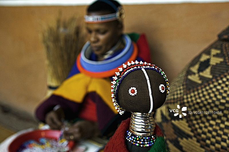 恩德贝莱族妇女制作色彩鲜艳的娃娃，风格为传统的恩德贝莱族服装。约翰内斯堡附近的莱塞迪文化村，南非图片素材