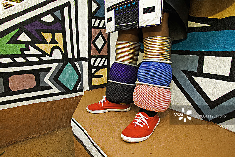 身穿传统服装的恩德贝勒族妇女，展示已婚妇女鲜艳的多色腿带。莱塞迪文化村，靠近南非约翰内斯堡。图片素材