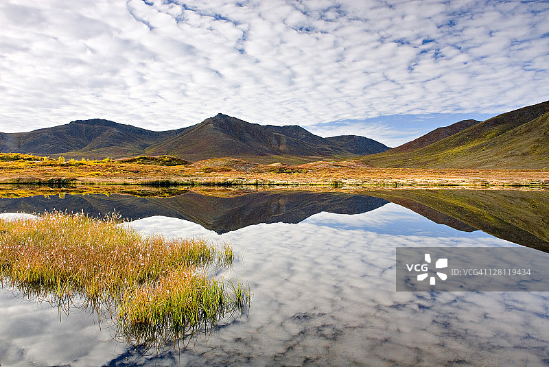 加拿大育空地区墓碑领地公园奥吉尔维山脉苔原湖泊的云彩和山脉倒影图片素材