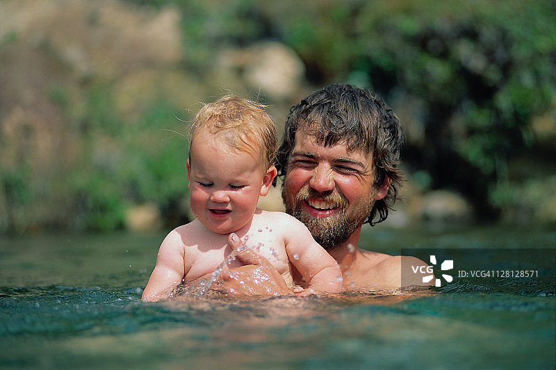 父亲和婴儿在黄石公园的温泉里图片素材