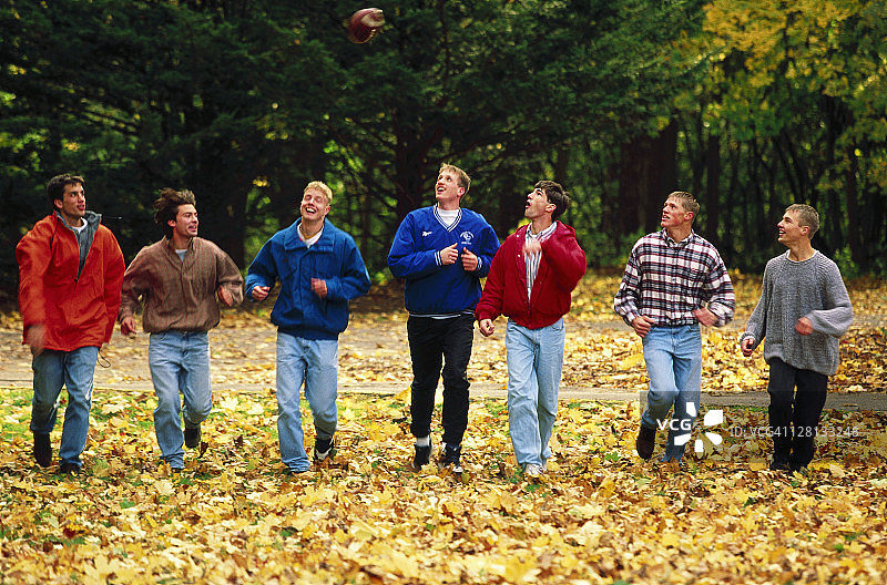 在密歇根州阿奎那斯学院拿着橄榄球的男学生图片素材