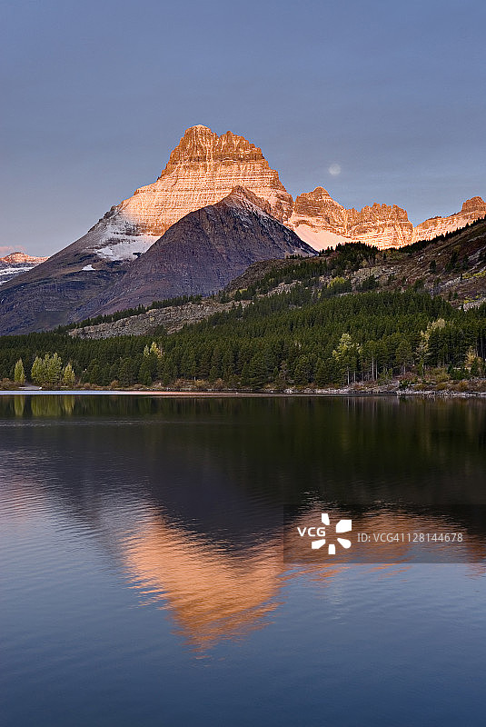 美国蒙大拿州冰川国家公园威尔伯山和斯威夫特克伦特湖上的黎明图片素材