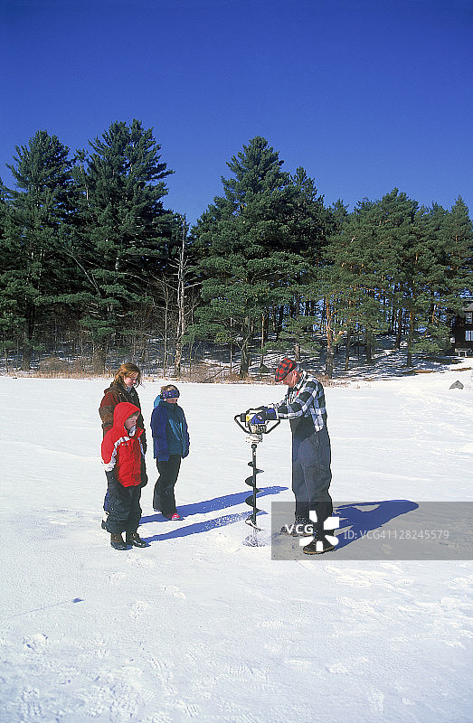 男人教家人冰钓，地点：佛蒙特州沙夫茨伯里湖州立公园图片素材