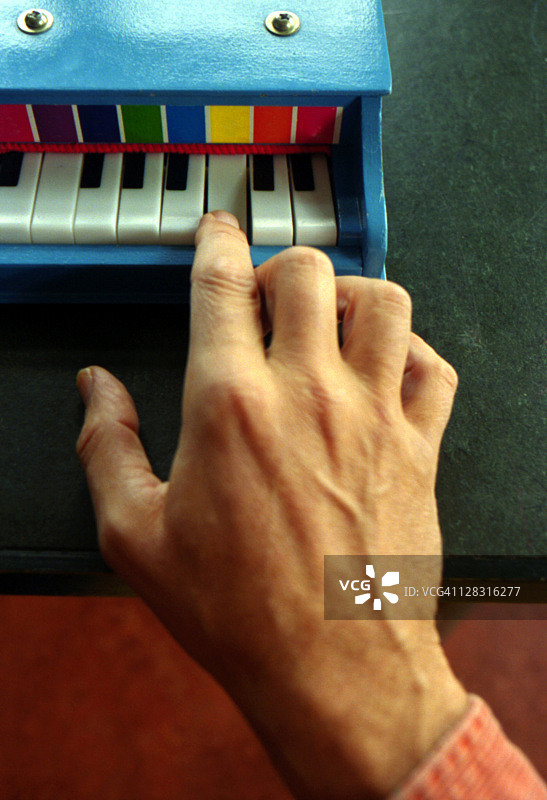 男人手弹奏儿童钢琴图片素材