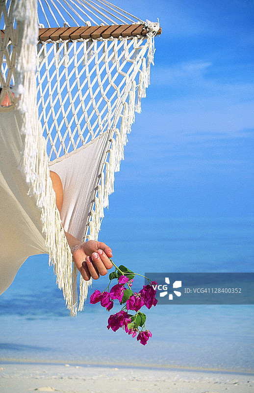 在阿里环礁白沙岛吊床上休息的女人图片素材