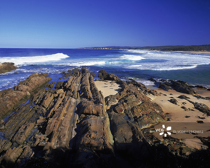 澳大利亚新南威尔士州米莫萨岩石国家公园中部海滩岩石上的波浪图片素材