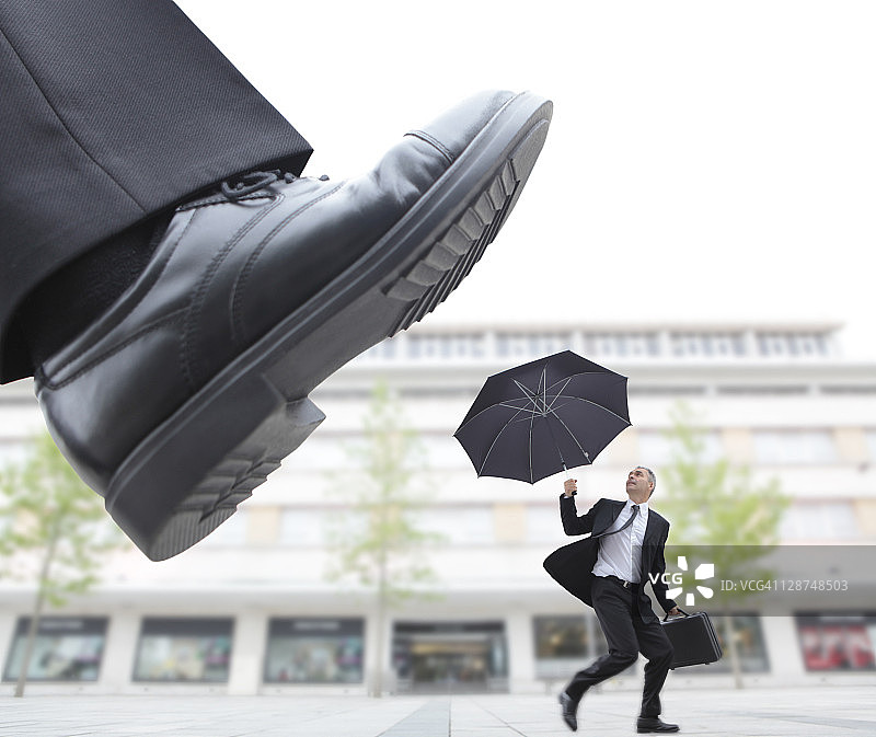 巨脚踩踏男性高管图片素材