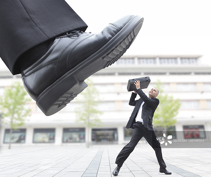 巨脚踩踏男性高管图片素材