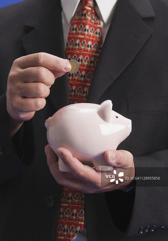 商人将墨西哥硬币放入银行图片素材