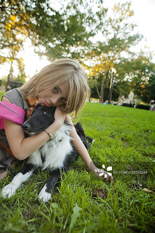 抱着烦躁小狗的悲伤女孩图片素材