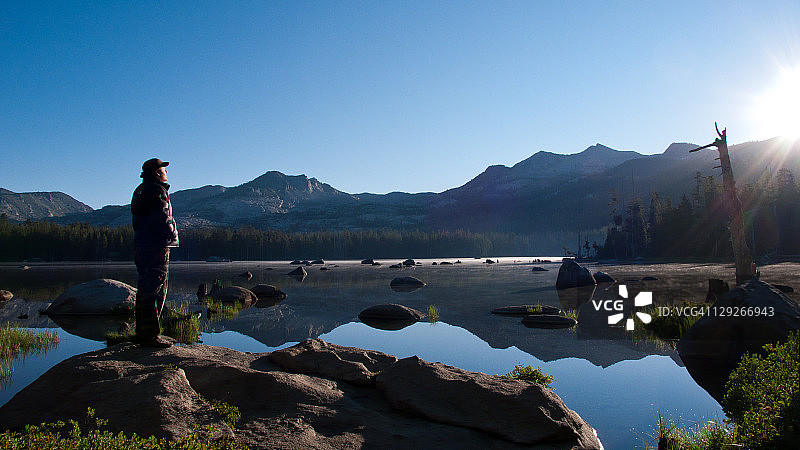 男人观看山间湖泊的日出图片素材