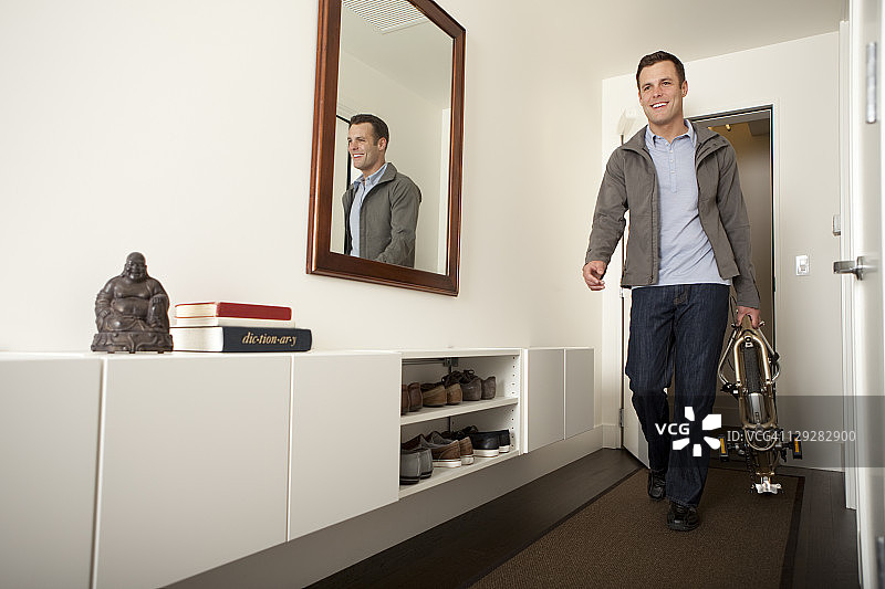 男子携带折叠自行车行走图片素材