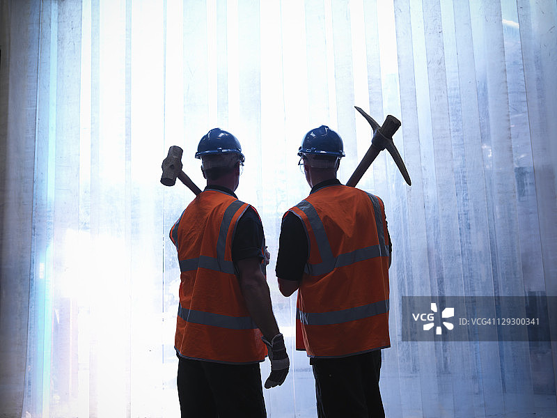 工人肩扛锤子和镐的剪影图片素材