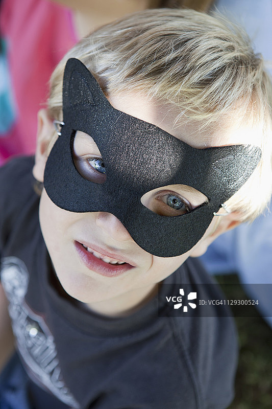 近距离拍摄：男孩戴着猫面具图片素材