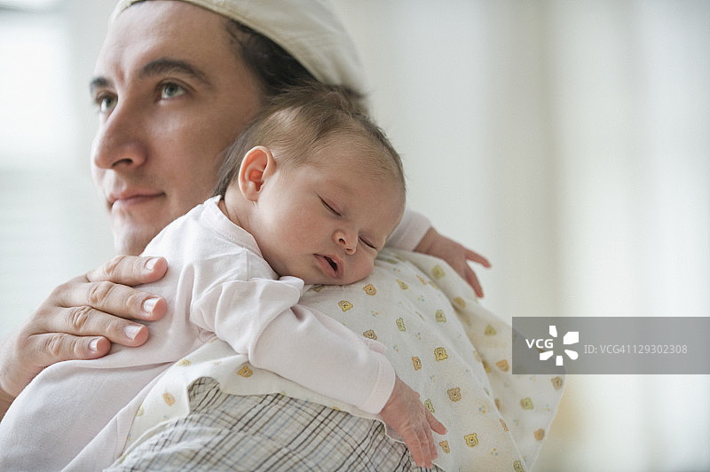 西班牙裔父亲给新生女婴拍嗝图片素材