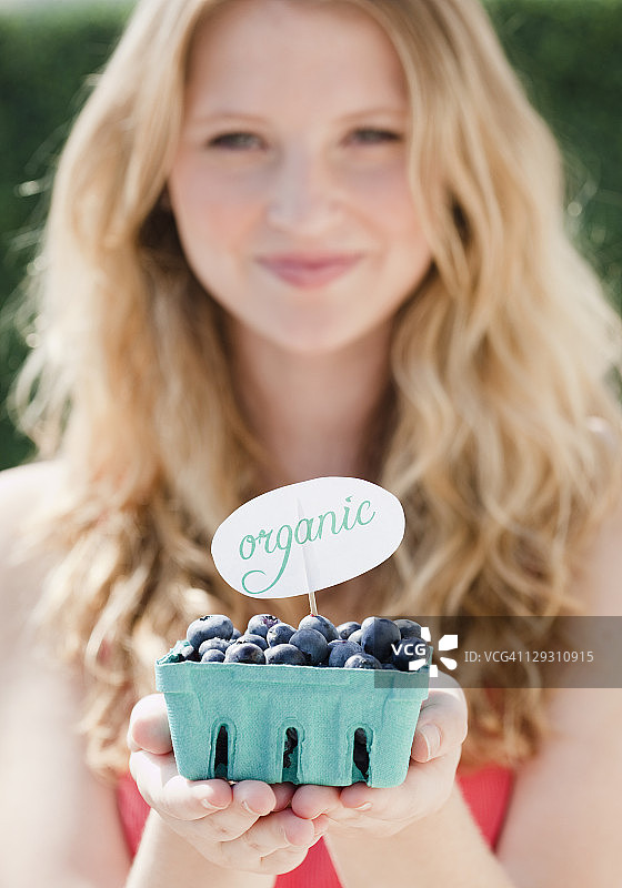 美国新泽西泽西市：年轻女子手拿有机蓝莓纸箱图片素材