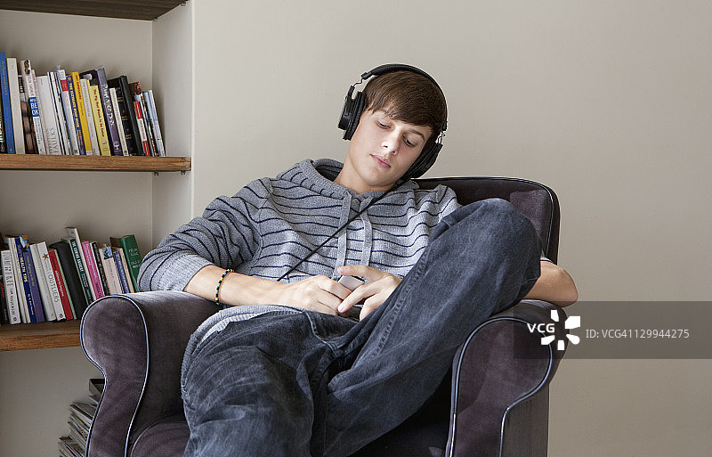 青少年男孩戴耳机听音乐图片素材