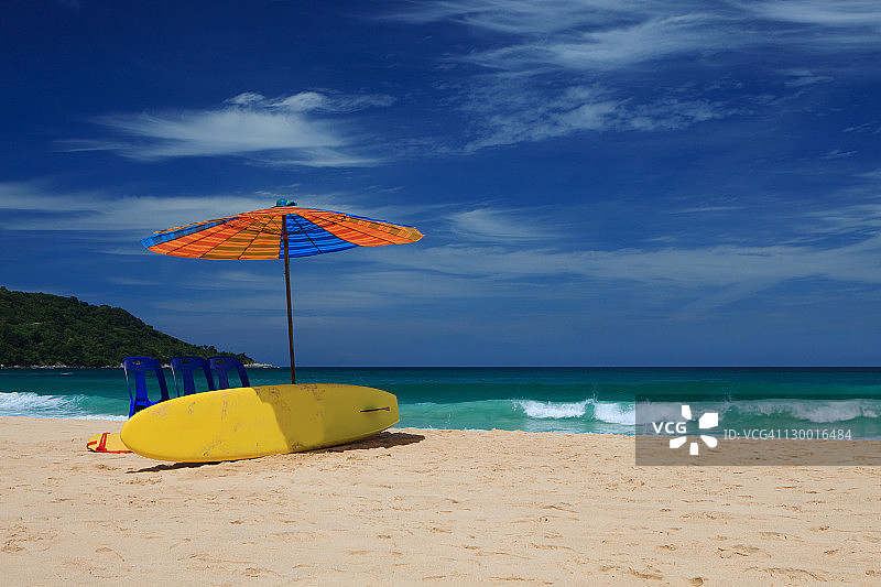 蓝色天空下孤立海滩上的遮阳伞图片素材