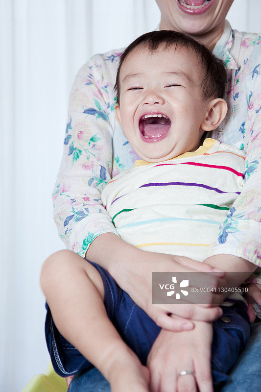 坐在妈妈腿上的男婴图片素材