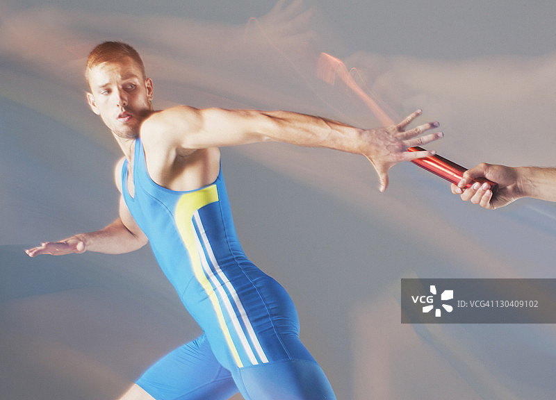 运动员传递接力棒的模糊景象图片素材