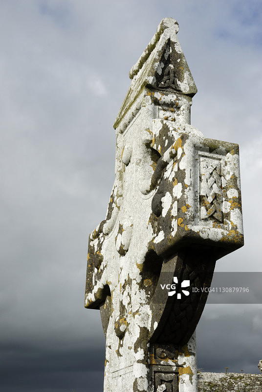 覆盖着黄色和白色地衣的凯尔特高十字，展示了典型的装饰品，爱尔兰米斯郡斯莱恩图片素材
