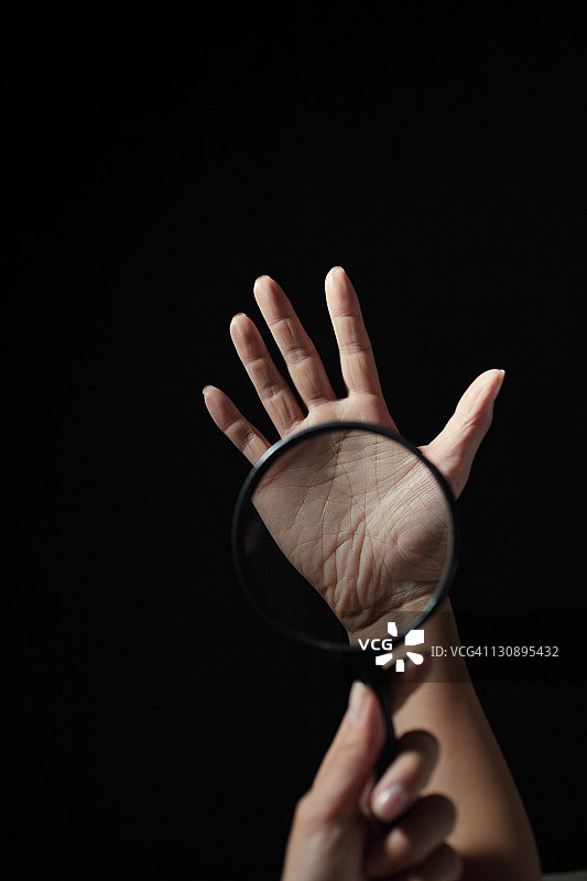 放大镜置于手掌之上图片素材