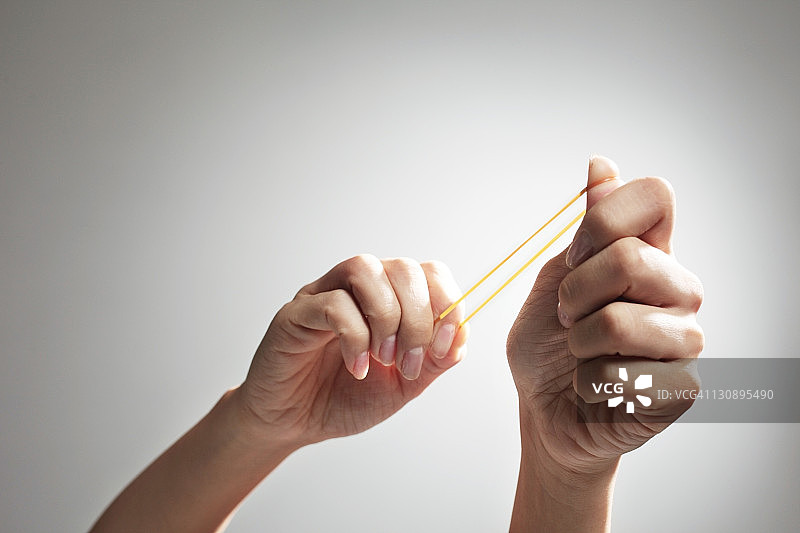 准备弹橡皮筋，手部特写图片素材