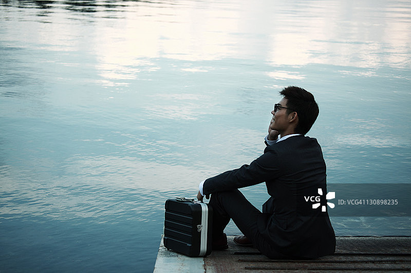 在湖边用手机交谈的商人图片素材