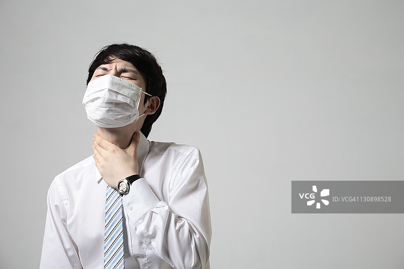 戴着口罩的年轻商人，身体状况不佳图片素材