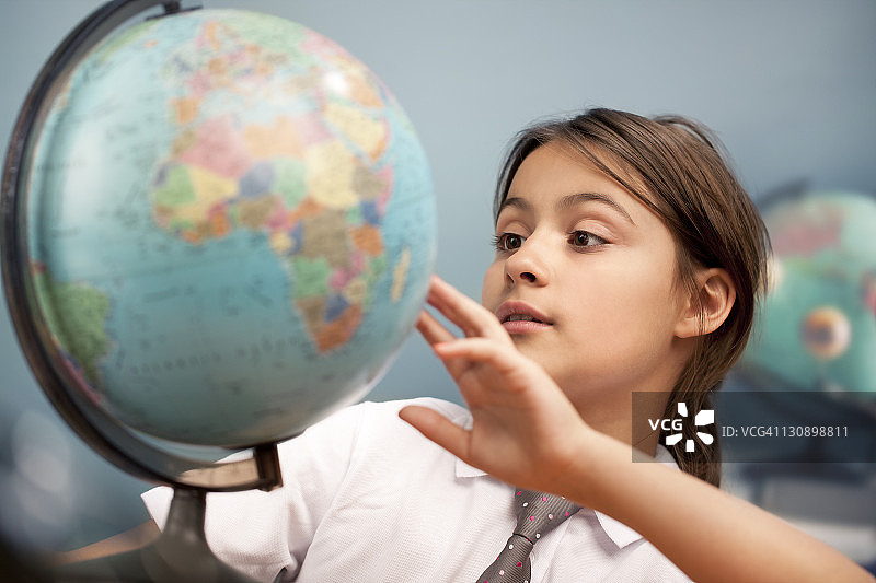 被地球仪深深吸引的女学生图片素材