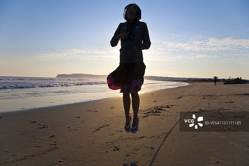 在海滩上跳跃的女孩轮廓图片素材