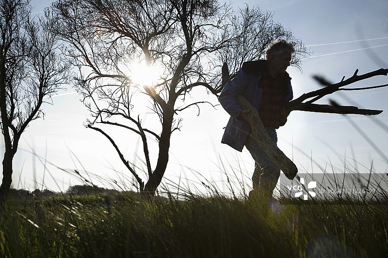 男人在田野里扛着棍子图片素材