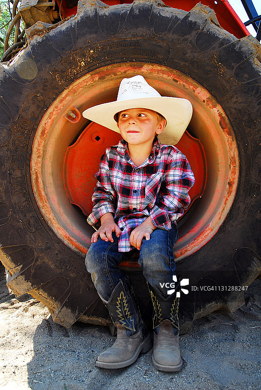 坐在拖拉机轮胎上的男孩（4-7岁）图片素材