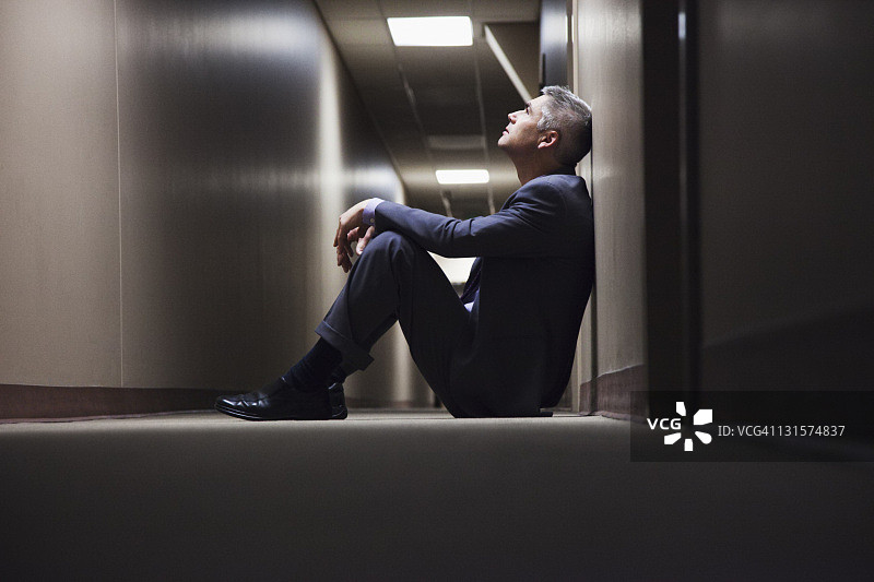 坐在走廊地板上的白人商人图片素材