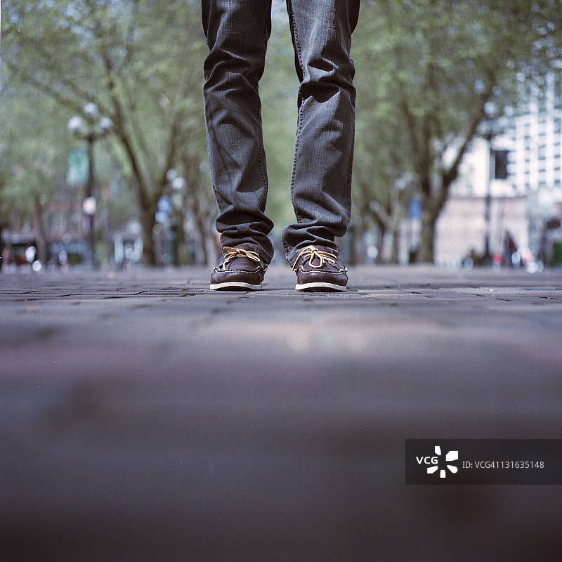 穿着棕色鞋子站在先锋广场的男人图片素材