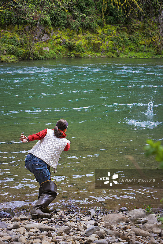 美国华盛顿州温哥华，女子在河边玩打水漂游戏图片素材