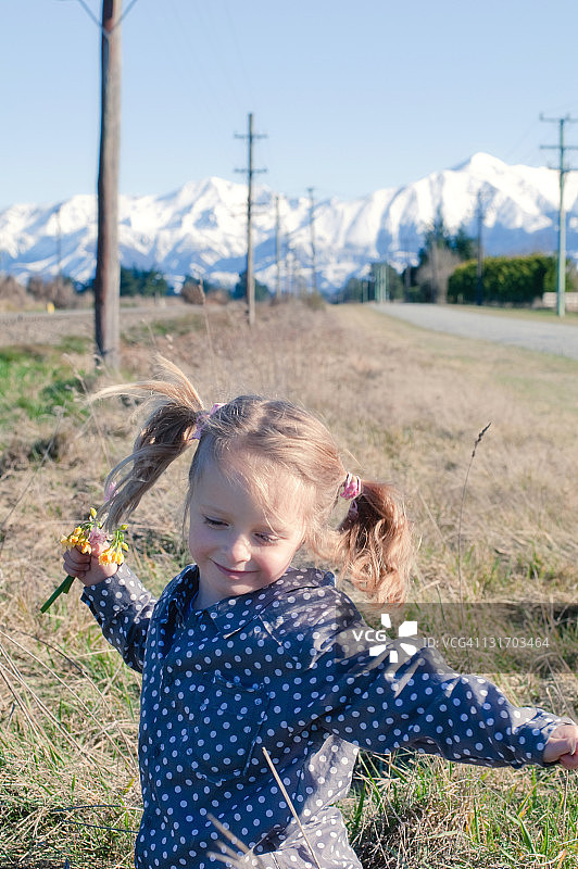 手持野花的微笑女孩图片素材