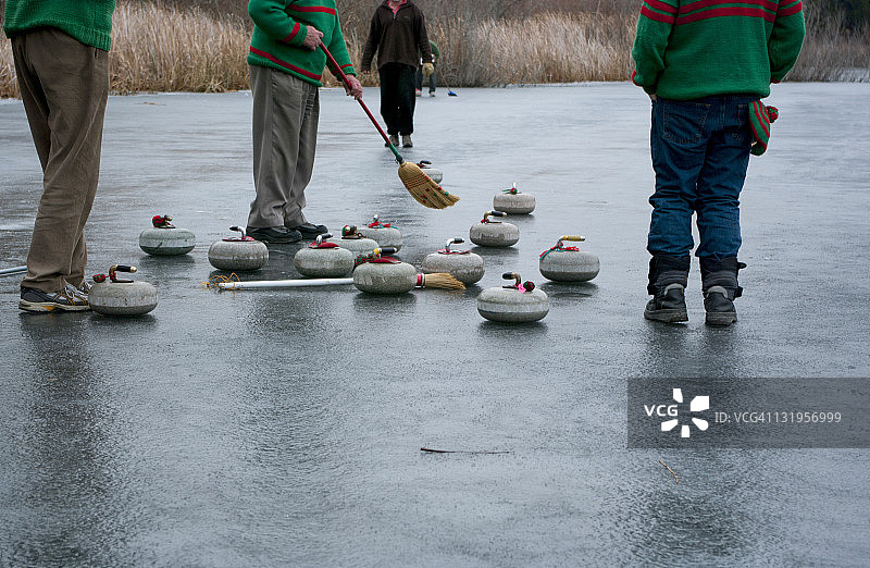 男人们在天然冰面上玩冰壶图片素材