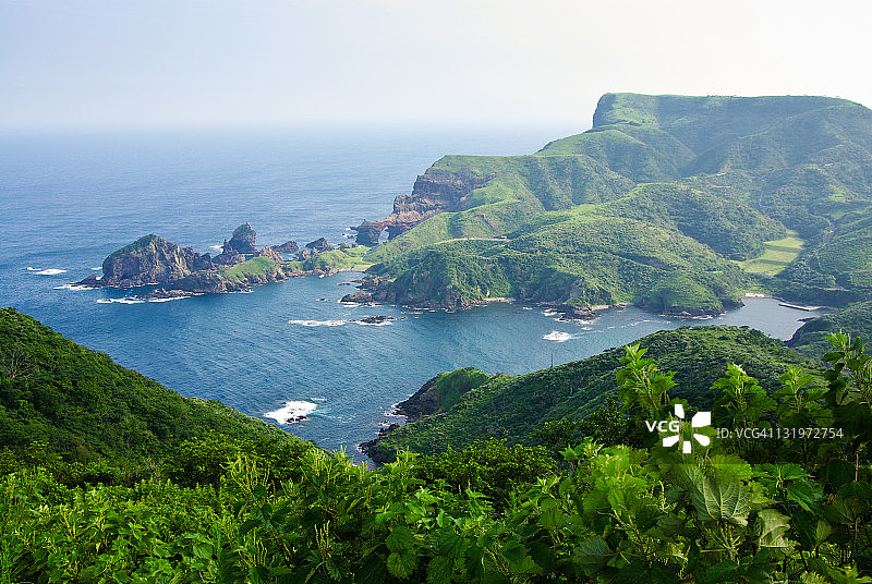 从上方俯瞰，隐岐群岛郁郁葱葱的绿色山丘和大海图片素材