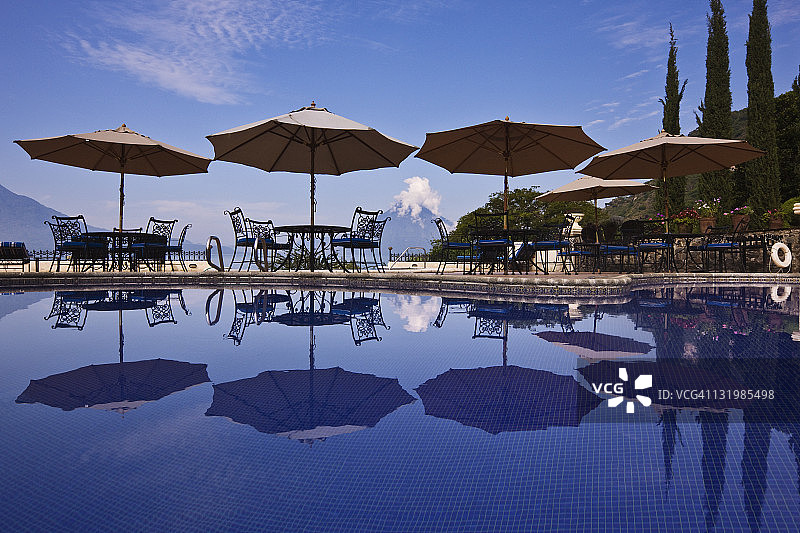 泳池边的雨伞、桌子和椅子图片素材