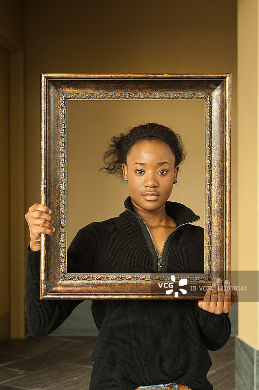 少女用相框框住她的脸庞图片素材