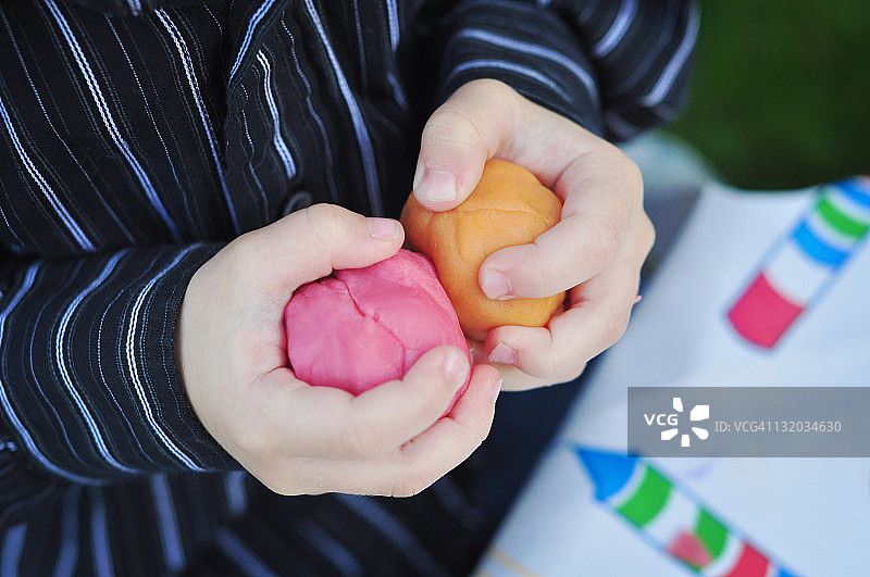 孩子的手拿着橡皮泥图片素材