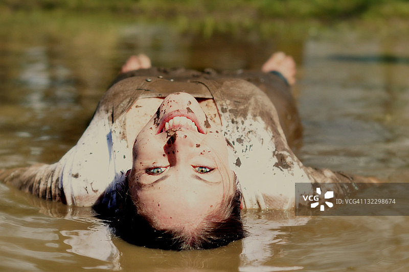 躺在泥地里微笑的女人图片素材